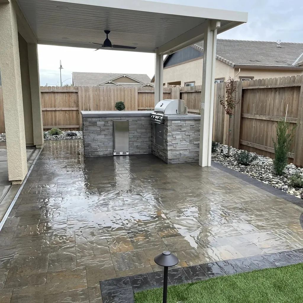 Covered patio with a stacked stone outdoor kitchen and built-in grill
