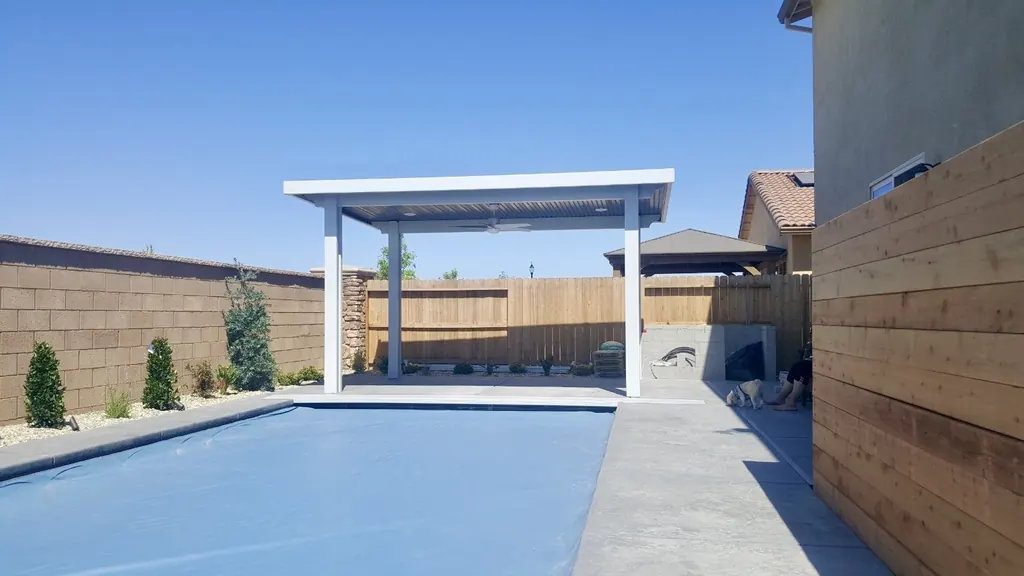 Pool with a white pergola at the far end of the deck