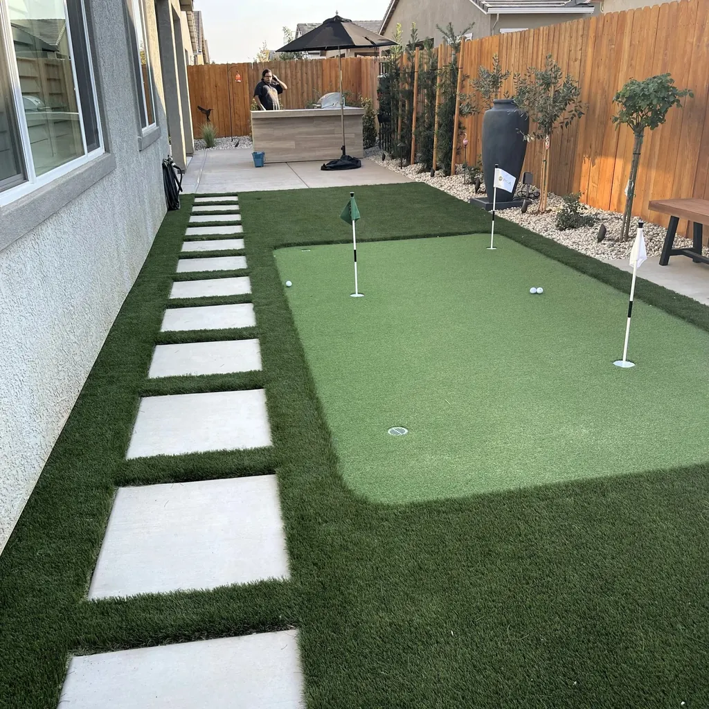Putting green beside a row of concrete steppers in a side yard