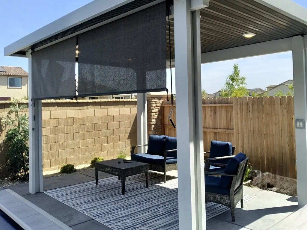 Covered lounge with roll-down shade screens and outdoor chairs