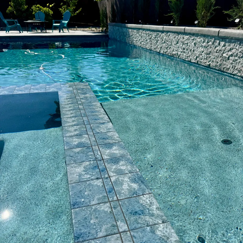 Pool steps and bench edged in dark tile