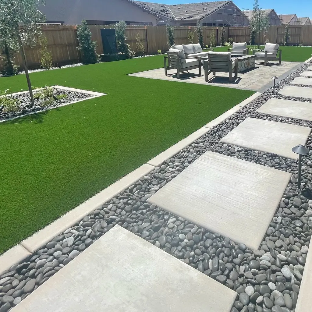 Backyard with new lawn, concrete steppers in river rock, patio seating, and planting beds