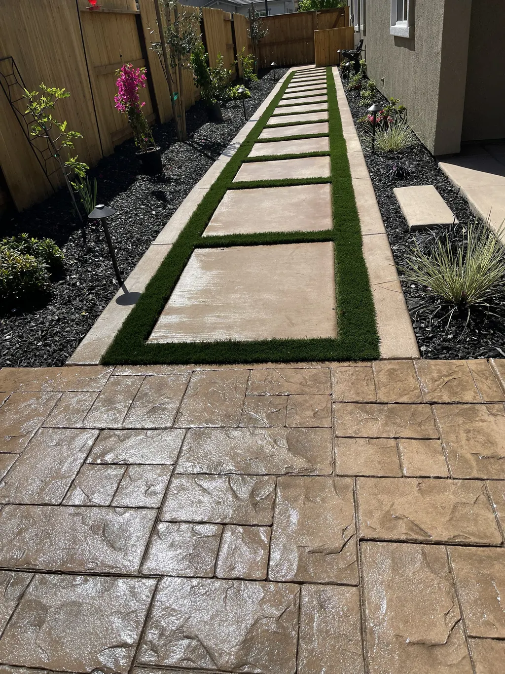 Concrete steppers with turf joints leading to a stamped concrete patio